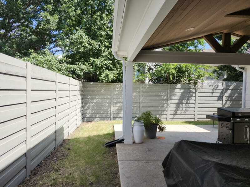 Light gray horizontal-board privacy fence around a covered backyard patio