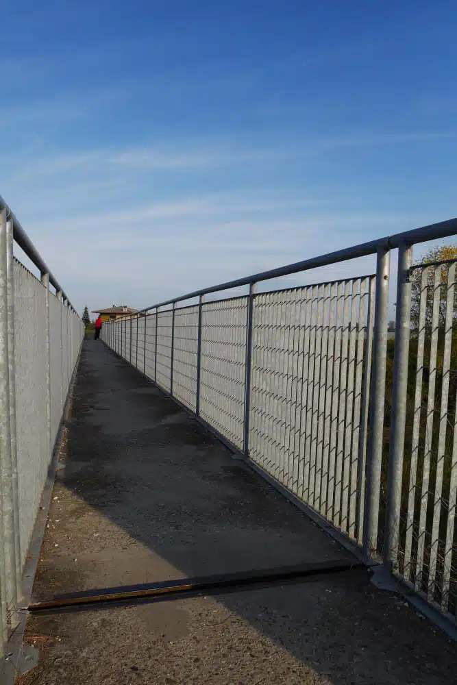 Galvanized metal railing along an outdoor walkway